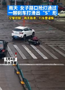女子雨天骑电动车抢灯过路口 遇右转车辆急刹车滑倒