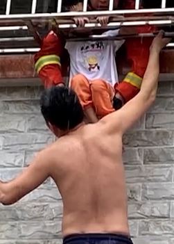女童头卡防盗网 男子踩梯子托举至消防解救后默默离开