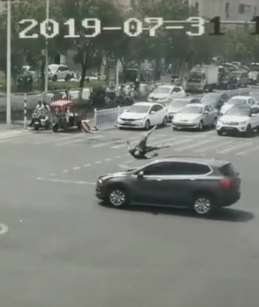 男子骑电车打电话闯红灯被撞飞