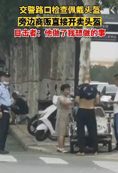 交警路口查佩戴头盔 商贩在一旁开卖