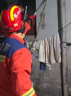 居民收衣服发现晾衣绳上挂着条蛇 消防员赶到后抓获放生
