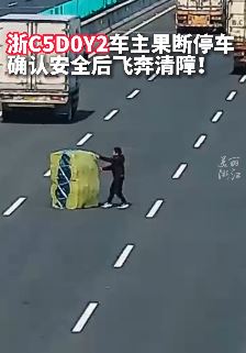 高速上货车掉落巨大货物 面包车司机将其挪到路边