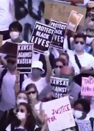 日本爆发游行示威 上千人手举牌子走上街头