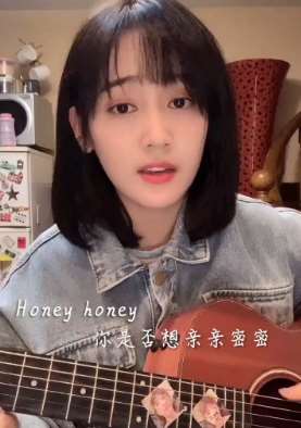 美女用吉他边弹边唱《哈尼哈尼》，歌声美极了！