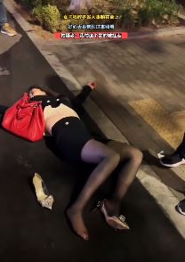 黑丝小姐姐醉酒街头躺地 热心大哥上前帮忙照看