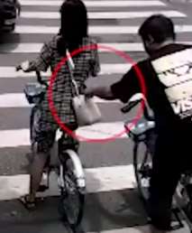 杭州街头一小偷正对一女子下手 快递小哥出现让小偷未得逞