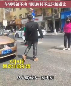 哈尔滨一男子斑马线上静止不动 经过车辆只好避让