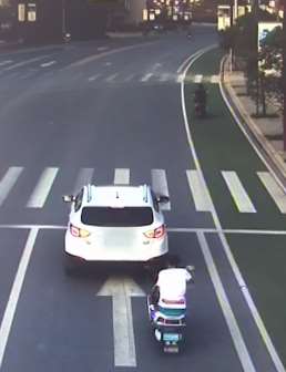 小伙骑电动车看手机，一个不注意撞上等灯小轿车