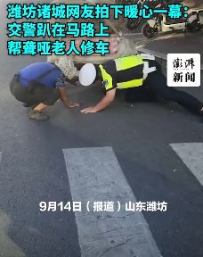 山东诸城一交警趴马路上帮聋哑老人修车