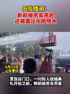 山东枣庄现低俗婚闹 新郎被吊车吊起用高压水枪喷水