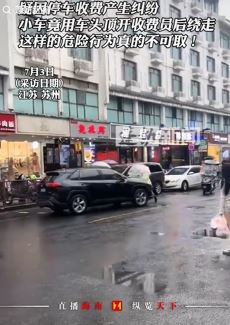 苏州一私家车因停车收费问题车头顶着收费员
