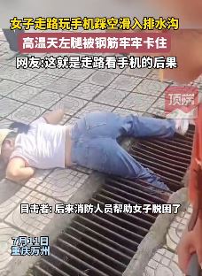 女子走路玩手机腿卡排水沟