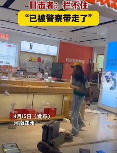 郑州一女子持棍子打砸电脑店铺被警察带走