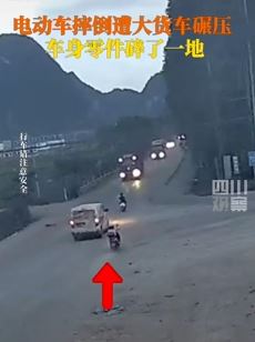 路人骑电动车摔倒险遭大货车碾压 人没事车被压粉碎