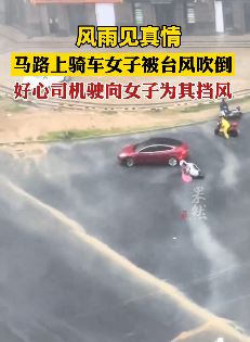 福建泉州一女子骑车被台风吹倒 好心司机将车开前面为其挡风