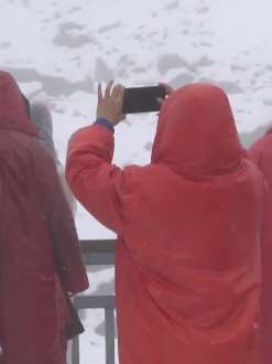 云南玉龙雪山8月降雪 游客冒雪拍照留念