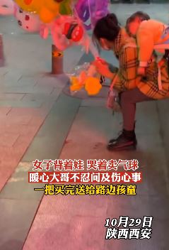 女子背娃哭着卖气球 暖心大哥全部买下送给路边孩童