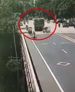 大货车为躲避电动三轮车一头栽进河里