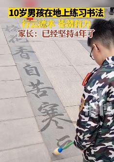 10岁男孩地上练书法 写出的字苍劲有力