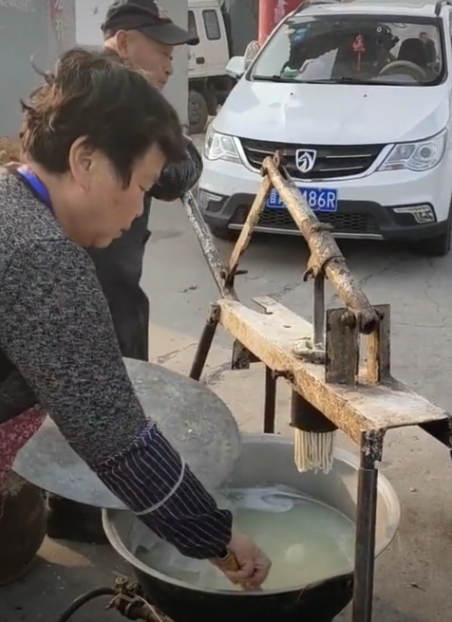这位大爷发明的饸络机不错,既环保又可锻炼身体!