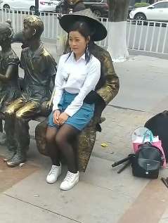 搞笑段子：女子坐铜人腿上拍照，结果吓一跳！