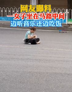 咸宁一女子坐马路中间吃饭