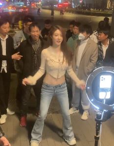 美女主播「罗玉姬子」街头直播热舞引围外,身后大叔才是焦点