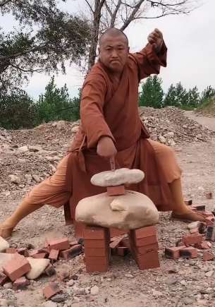 少林武僧表演一指禅戳断鹅卵石