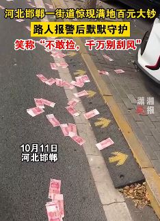 河北邯郸一路边全是百元大钞 路人报警后原地守护