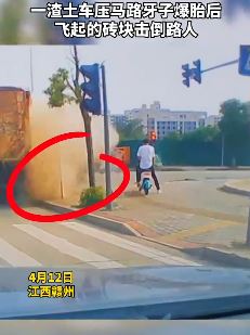 渣土车压马路牙子爆胎致飞起的砖块击倒路人