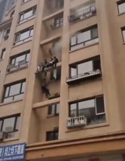 哈市一居民楼起火 多个孩子爬楼外横梁避火