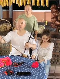 王小利展示才艺表演京胡名曲《夜深沉》 美女拿话筒一旁协助