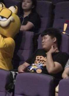 小情侣看电影，一旁的加菲猫却态度暧昧，女友尴尬了